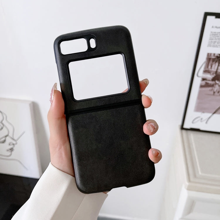Two-tone leather phone case, black cowhide texture, front view held in a hand.