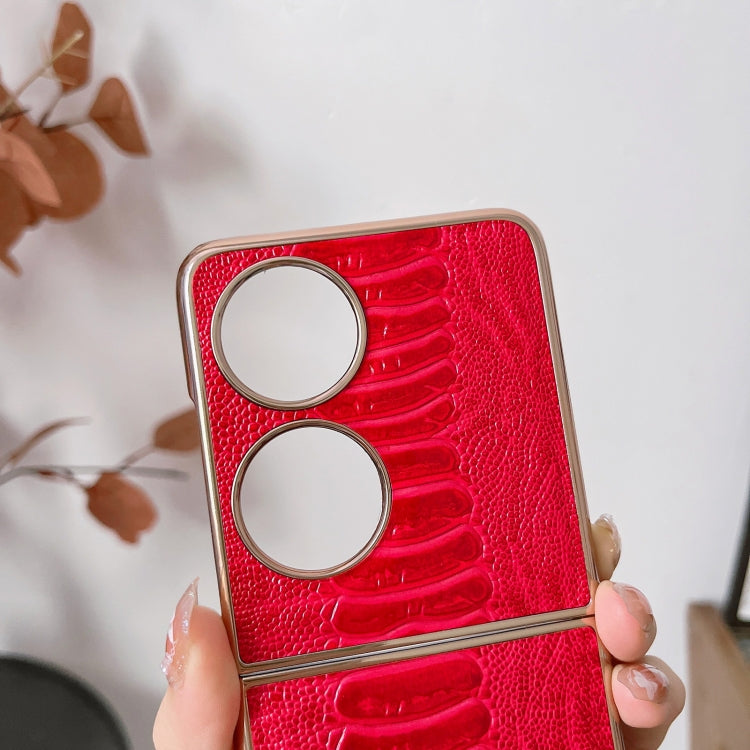 Red croc-texture phone case close-up with two metal rings and camera opening