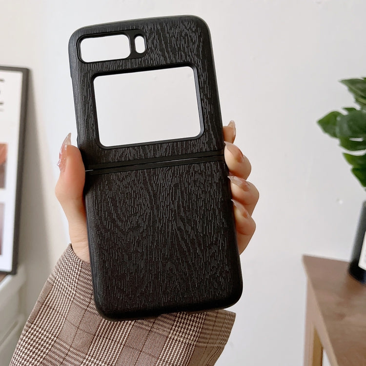 Black wood-texture PU phone case held in hand, camera and screen cutouts