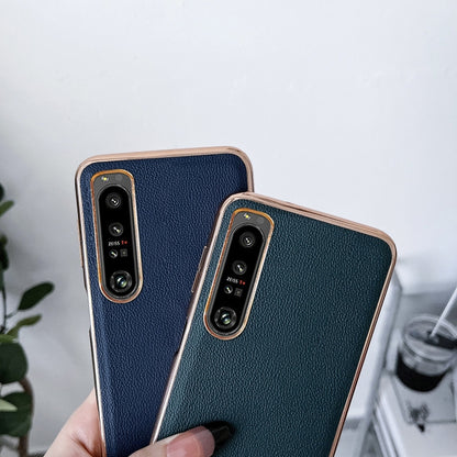 Pair of leather phone cases in black and dark green; camera cutouts visible.
