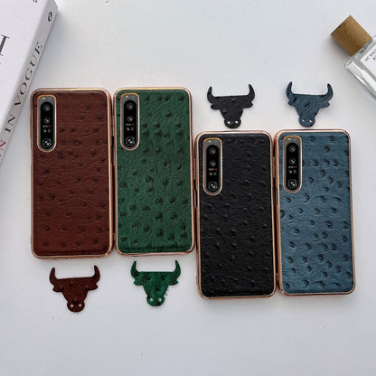 Set of leather phone cases with ostrich-texture finish in brown, green, black, and blue.