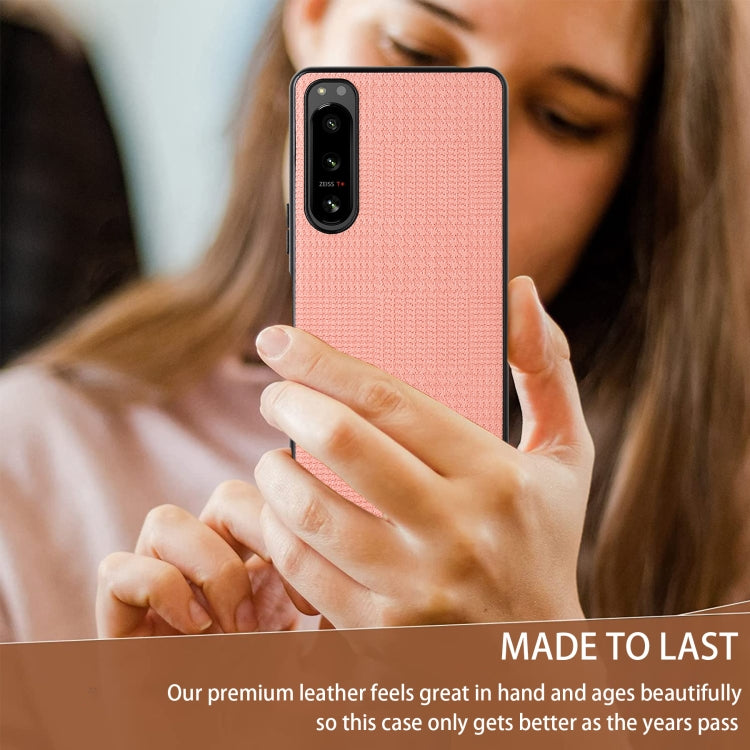 Pink shockproof phone case held on a phone with textured back and camera cutout