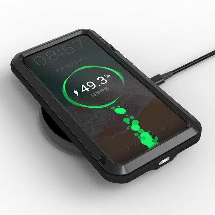 Black rugged phone case on its back, showing port openings and protected display