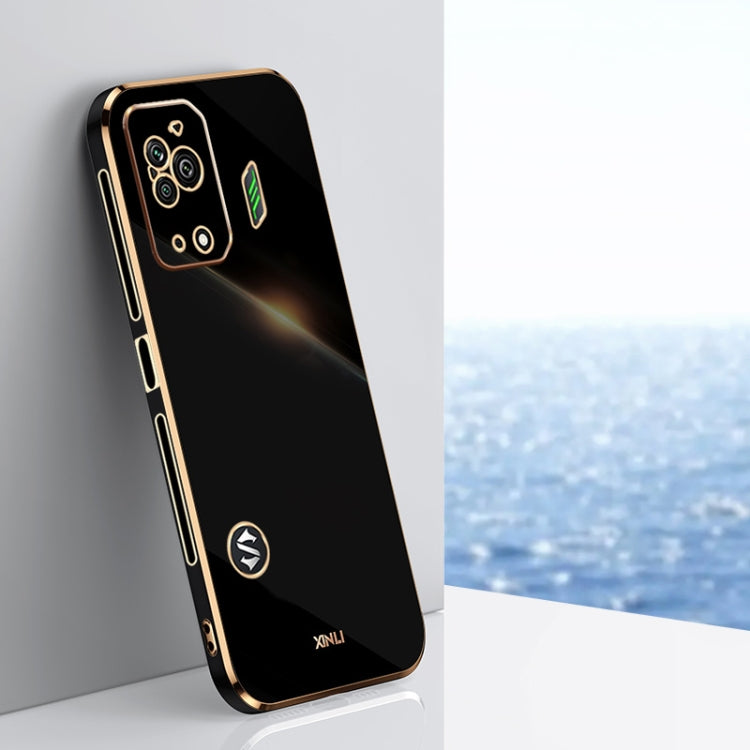 Black TPU phone case with gold-tone straight edges, camera cutouts, and decorative icons