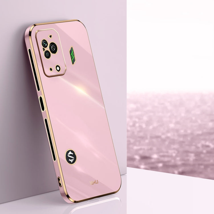 Pink TPU phone case with gold-tone straight edges, camera cutouts, and decorative icons