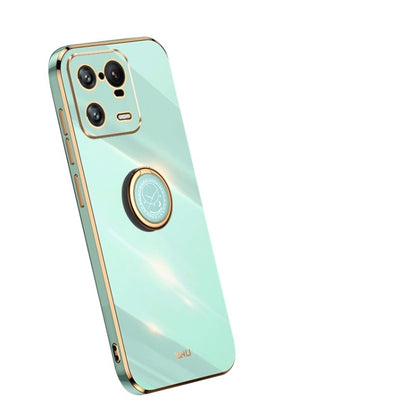 Mint green TPU case with gold trim, ring holder, and camera cutouts