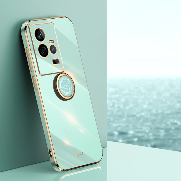 Mint green TPU phone case with gold electroplate edges and ring holder near camera