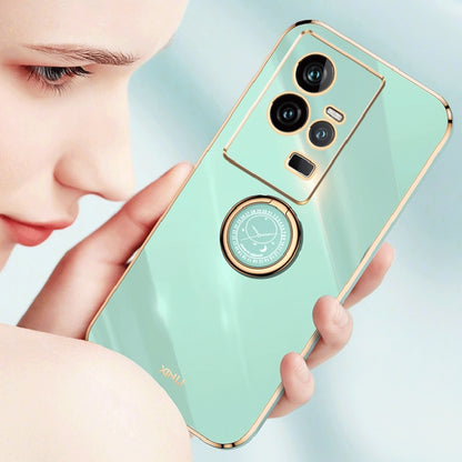 Mint blue TPU phone case with gold ring holder and triple-camera lens openings