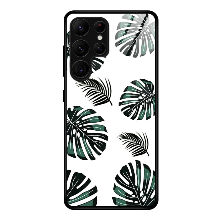 Glass phone case with green tropical leaf pattern and black phone frame cutouts