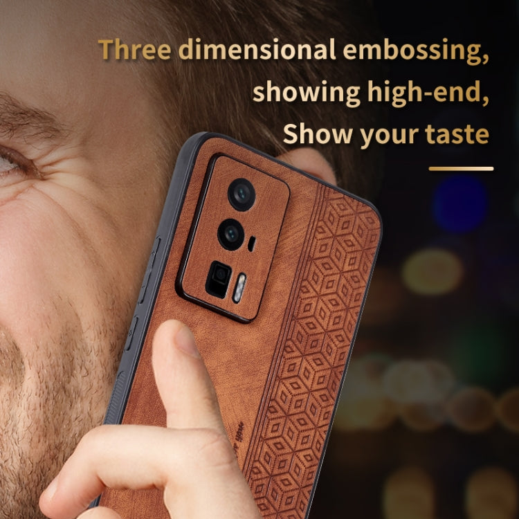 Brown embossed phone case close-up with camera cutout and textured geometric pattern