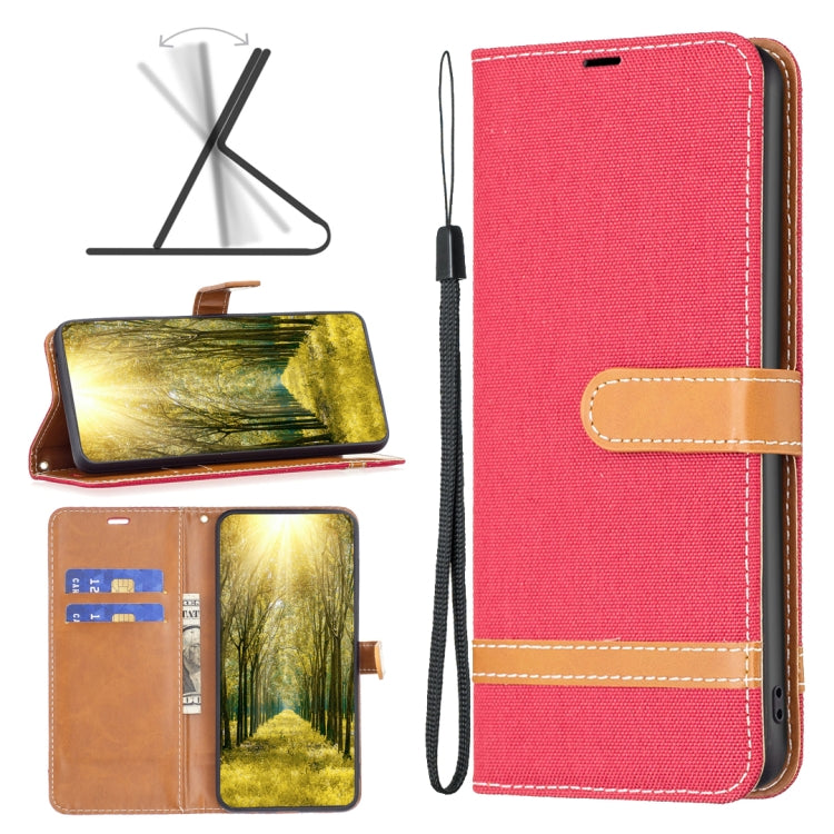 Red denim-texture leather phone case with tan wrist strap and stitched accents