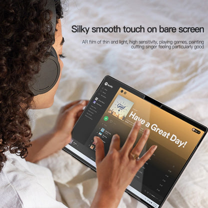 Clear AR screen film on a tablet, with hands touching the display