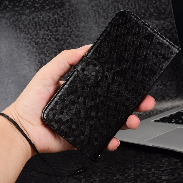 Black honeycomb dot leather phone case in hand with circular snap tab detail
