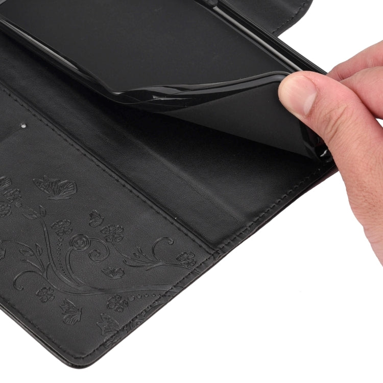 Black leather phone case interior with embossed butterfly-flower pattern and inner flap