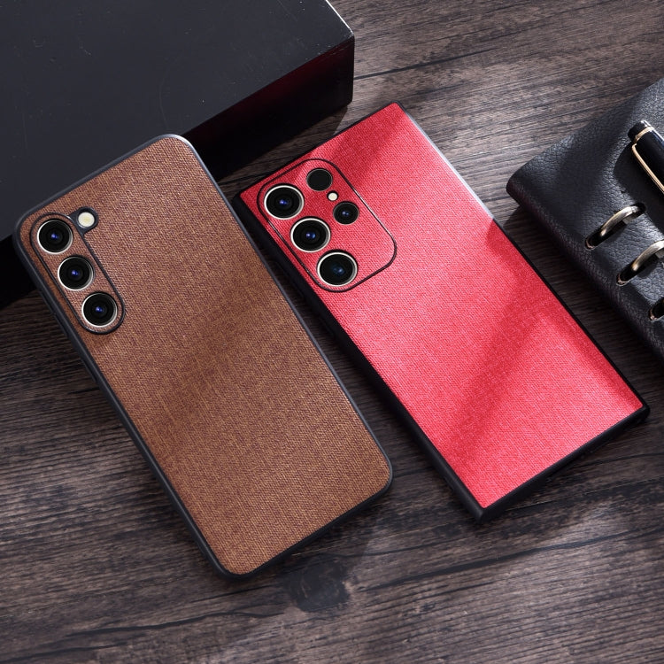 Cloth-texture phone cases in brown and red with camera lens cutouts