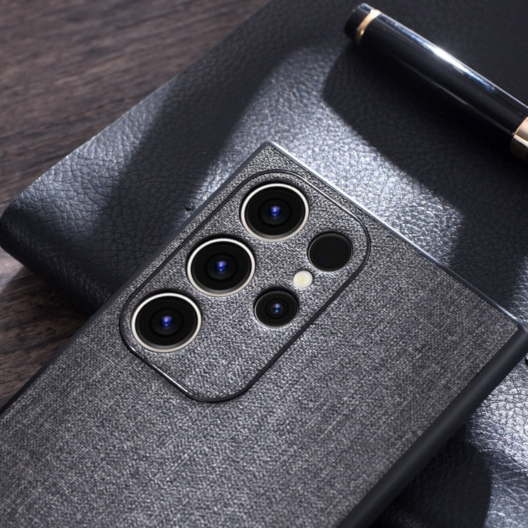 Grey cloth-texture phone case close-up with triple camera cutouts and flash