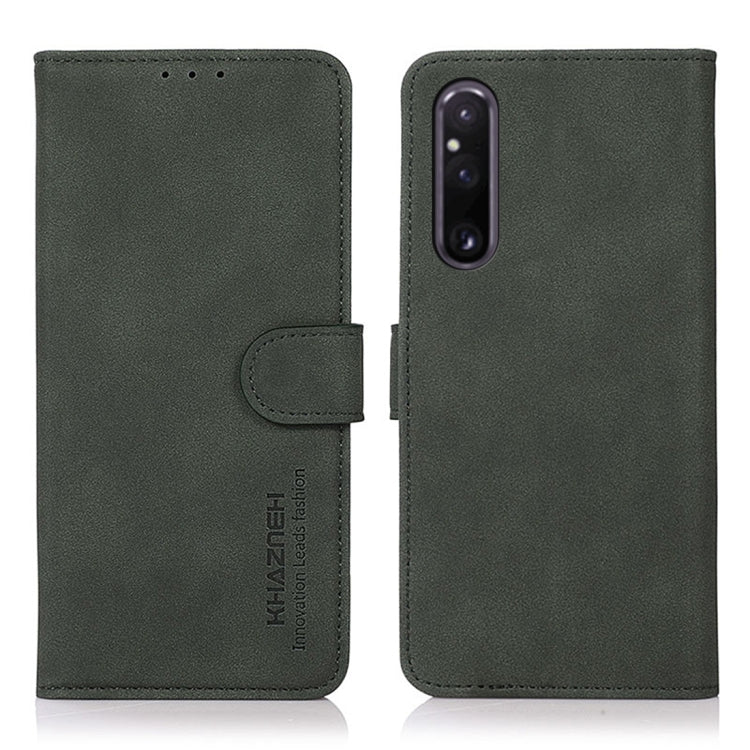 Matte green leather phone case with flip cover and holder strap; camera cutout.