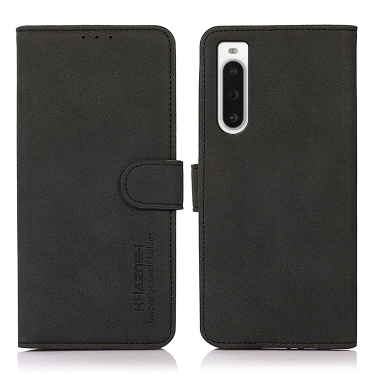 Black matte texture leather phone case front and back, with folio flap and strap.