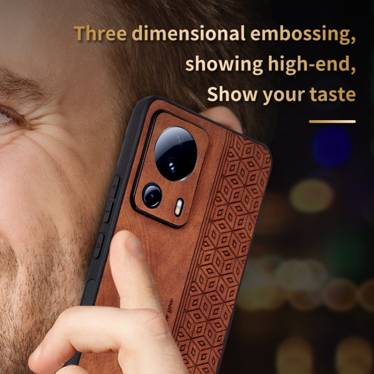 Brown phone case with 3D embossed pattern and camera cutouts, held in a hand