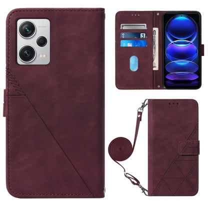 Wine red leather flip phone case with geometric embossed side and crossbody strap.