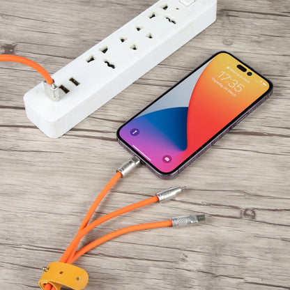 Orange 3-in-1 charging data cable with metal plugs connected to a smartphone and power strip