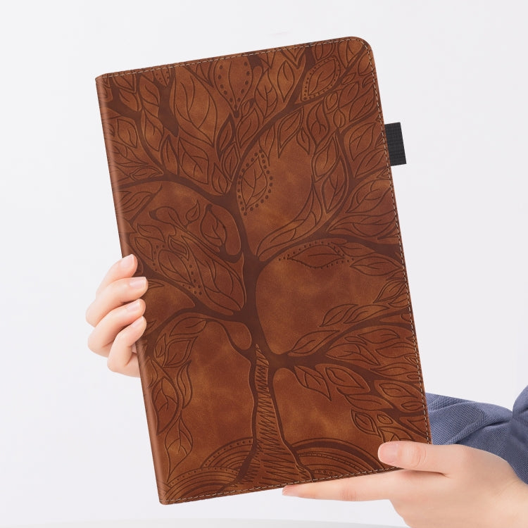 Brown leather folio tablet case with tree pattern; cover shown upright in hands