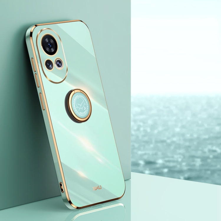 Mint green TPU phone case with ring holder and gold-tone edge accents.