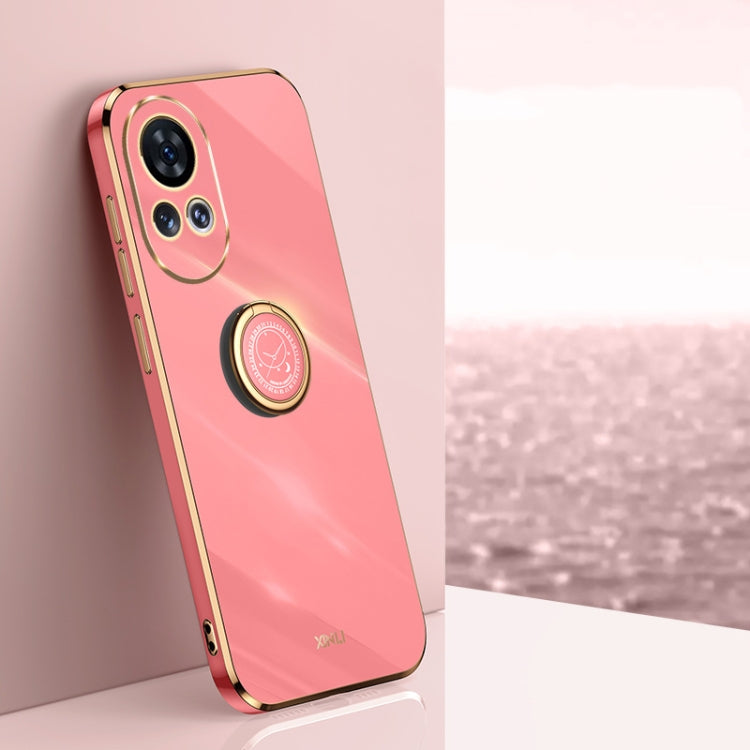 Coral pink TPU phone case with ring holder and gold-tone edge accents.