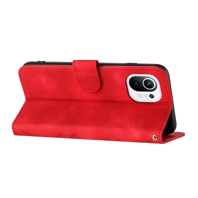 Red flip wallet phone case with textured cover and camera cutout, wrist strap loop
