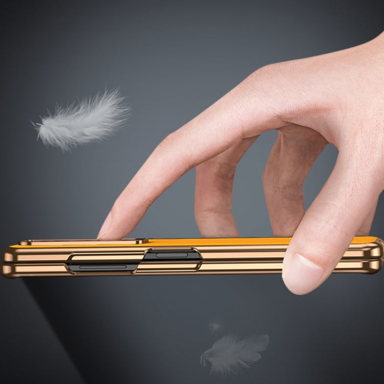 Gold-tone folding leather phone case with electroplated metal frame, hand-held close-up