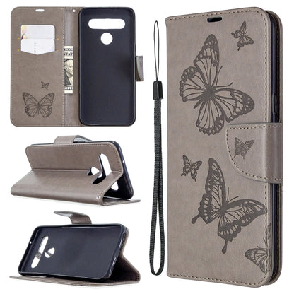 Grey leather-style phone wallet case with embossed butterflies, card slots, and wrist strap