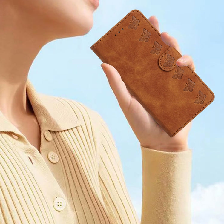 Brown leather folio phone case with embossed butterflies, held in hand
