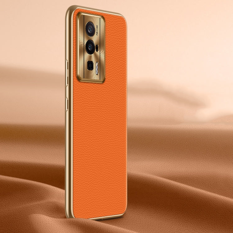 Orange litchi-texture genuine leather phone case, back view with camera cutout.