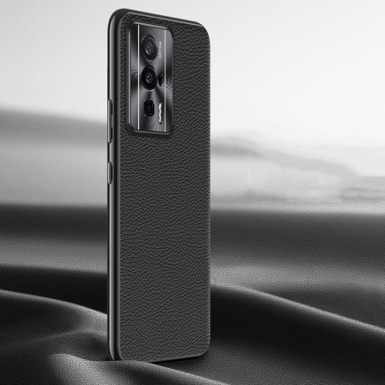 Black litchi-texture genuine leather phone case, back view with camera window.