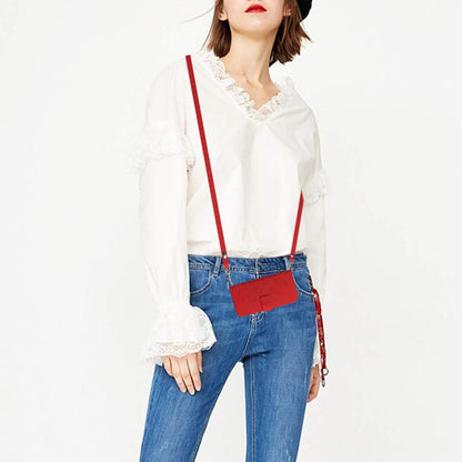 Red lanyard phone case worn crossbody with denim outfit