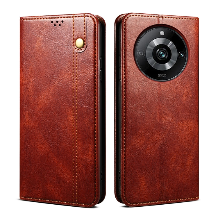 Red leather phone case with stitched edge, gold button, and circular camera cover