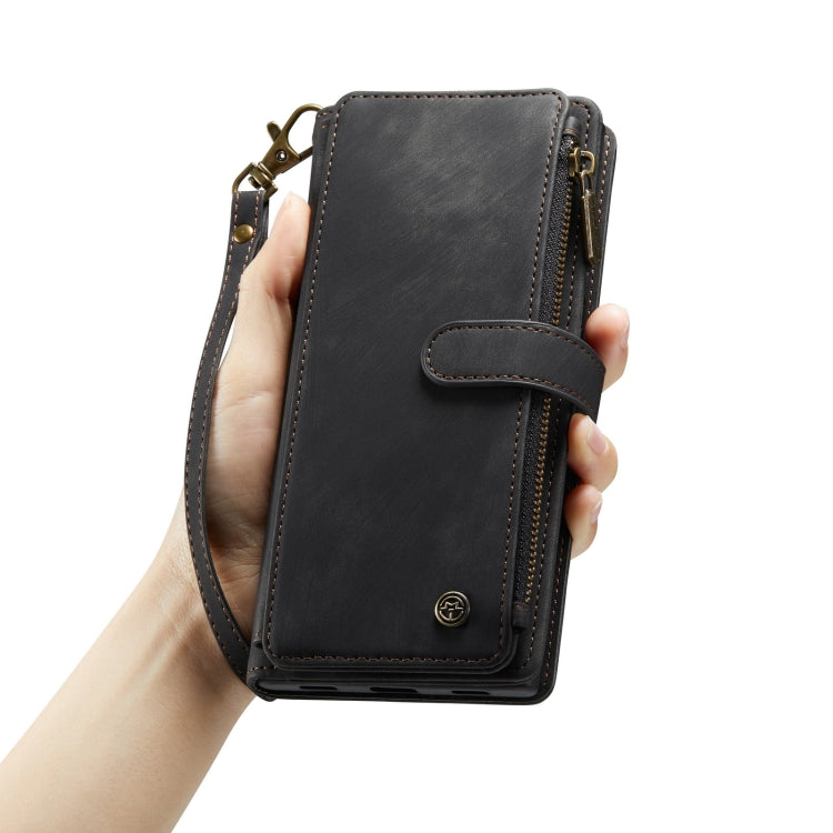 Black leather phone wallet case held in hand with wrist strap and zipper