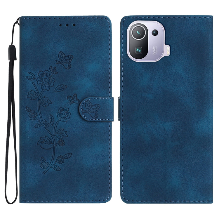 Blue leather folio phone case with embossed flower and butterfly pattern, wrist strap