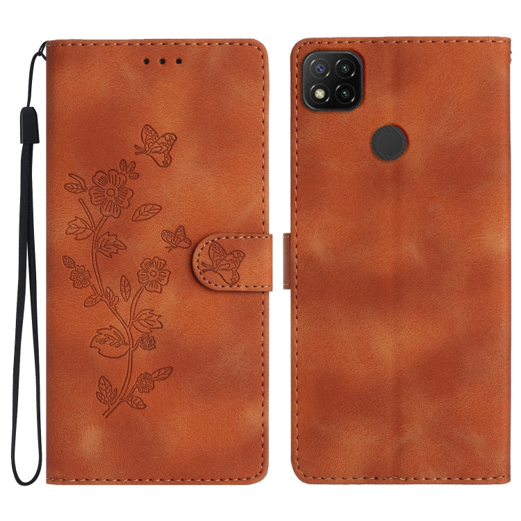 Brown embossed leather phone case with butterfly-flower pattern, wrist strap, flip cover.