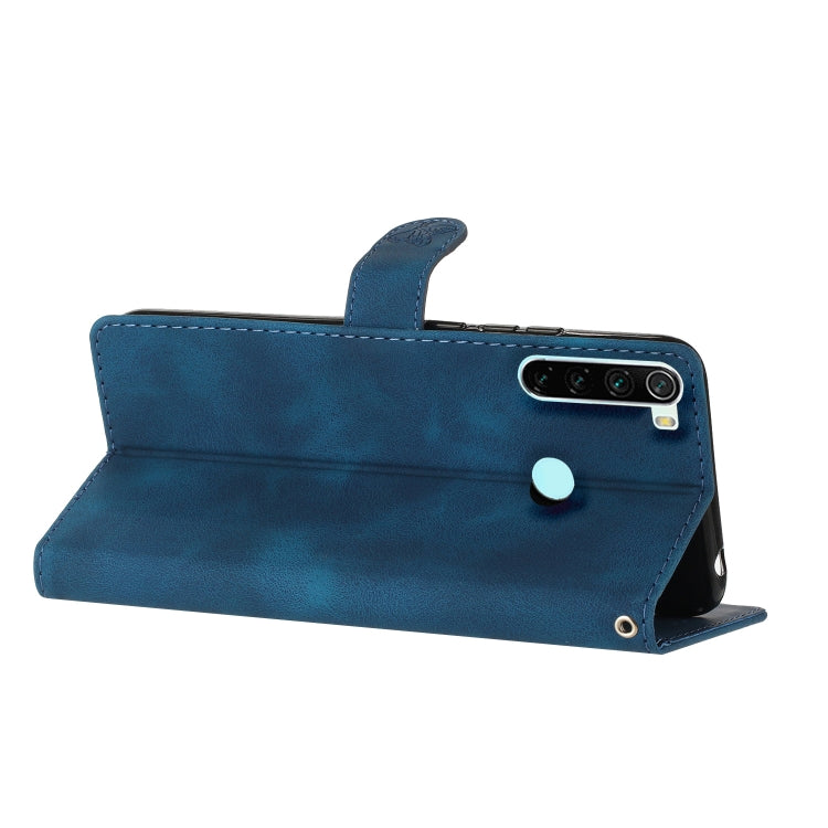 Blue leather flip phone case with built-in stand and camera cutout at top