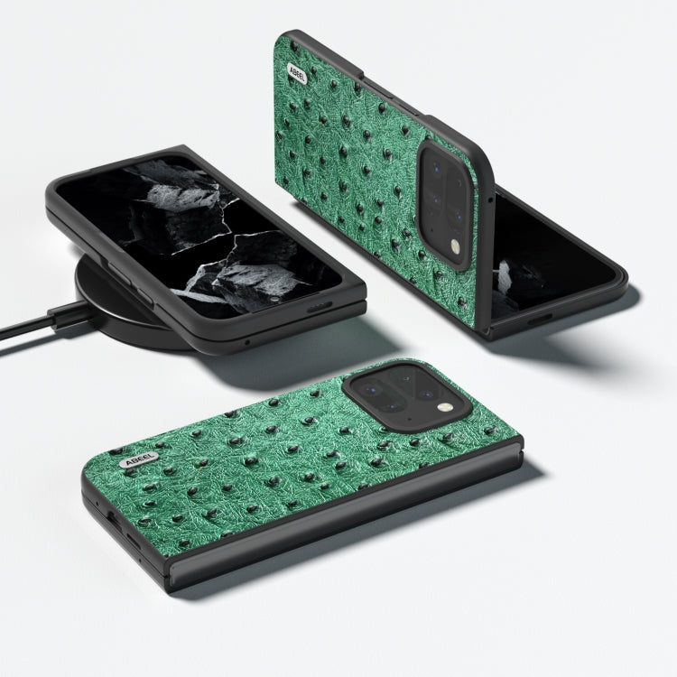 Green ostrich-textured leather fold phone case shown open, with camera cutout