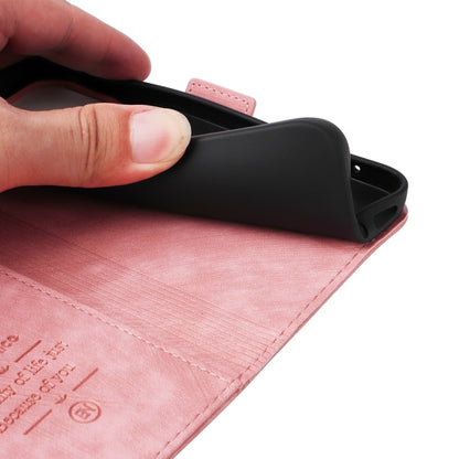 Pink leather phone case with wrist strap and side protective cover; hand inserting phone.