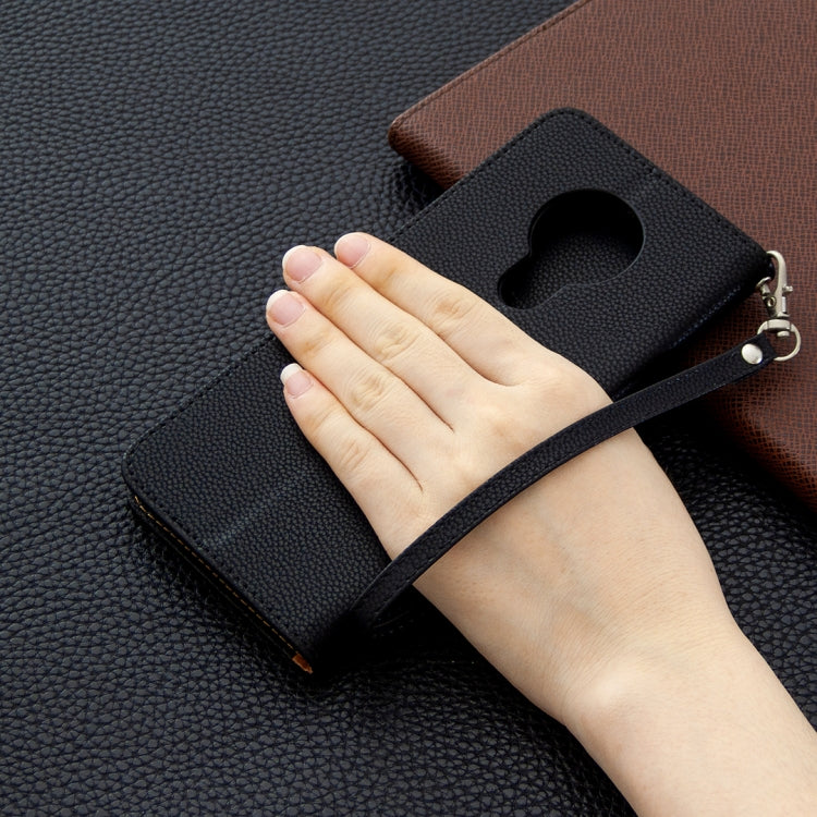 Textured leather flip phone wallet case with strap and card holder, shown with hand.
