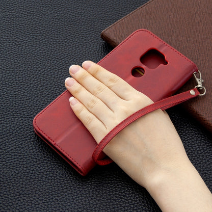 Red PU leather wallet phone case with wrist strap and camera cutout, hand holding