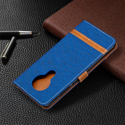 Blue denim flip wallet phone case with camera cutout and brown side strap