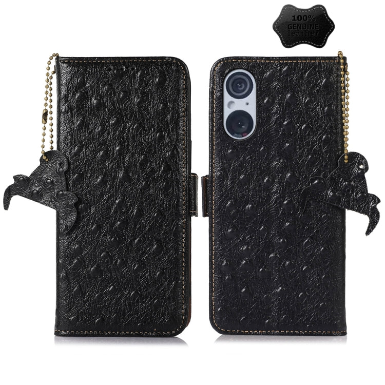 Black ostrich leather phone wallet case with dual camera cutout, animal charm and strap