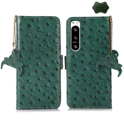 Green ostrich leather phone wallet case with single camera cutout, animal charm and strap