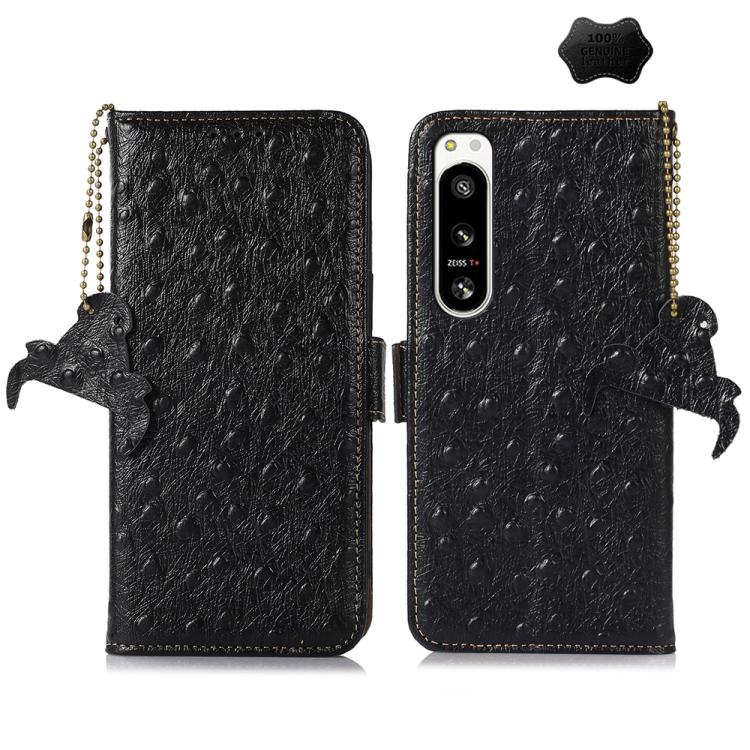 Black ostrich leather phone wallet case with single camera cutout, animal charm and strap