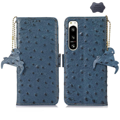 Blue ostrich leather phone wallet case with single camera cutout, animal charm and strap