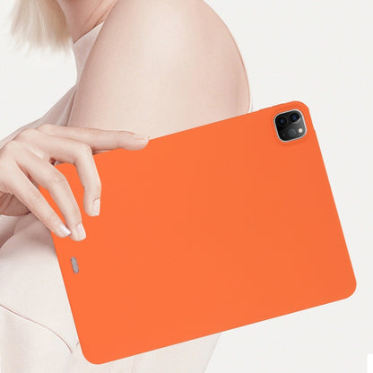 Orange tablet case held in hand with camera opening on the top corner.